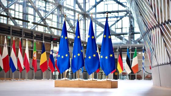 Vier EU-Flaggen im Vordergrund und die EU-Mitgliedsflaggen im Hintergrund